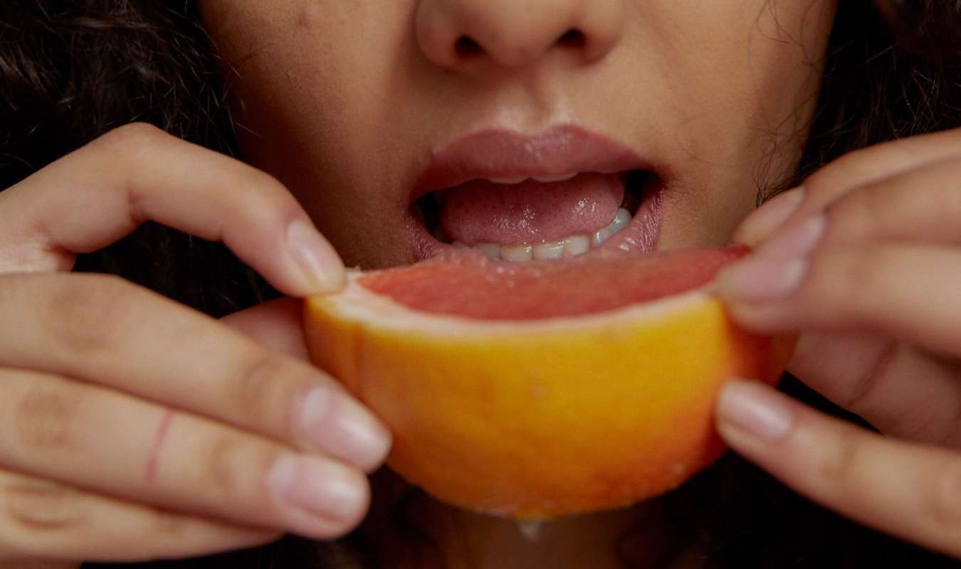 woman eating blood orange