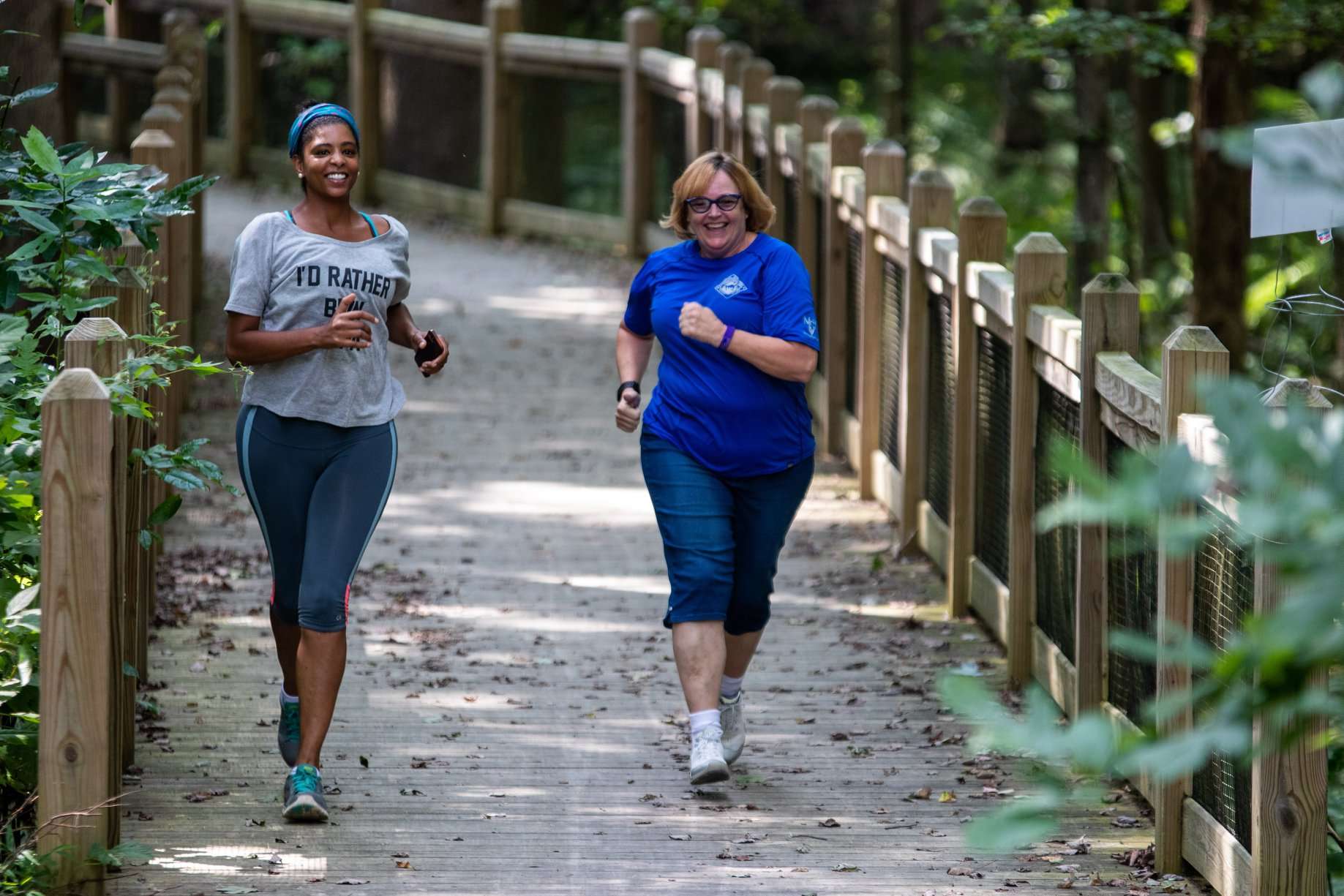 two woman running an smiling