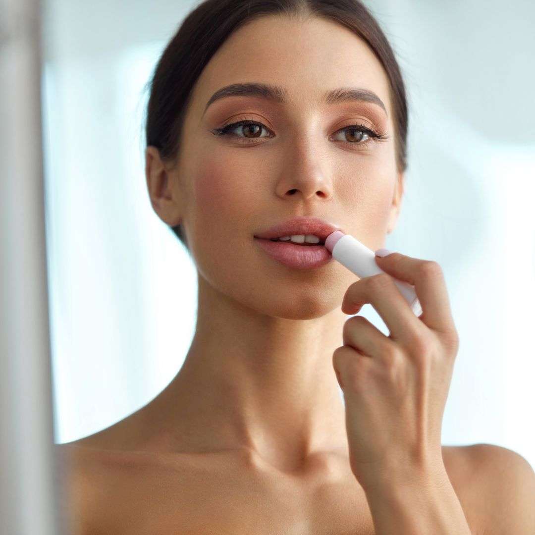 woman putting on chapstick