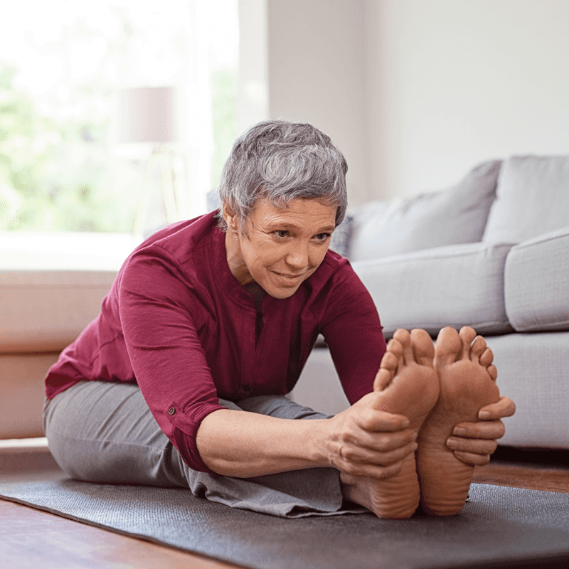 older woman with grey hair stretching