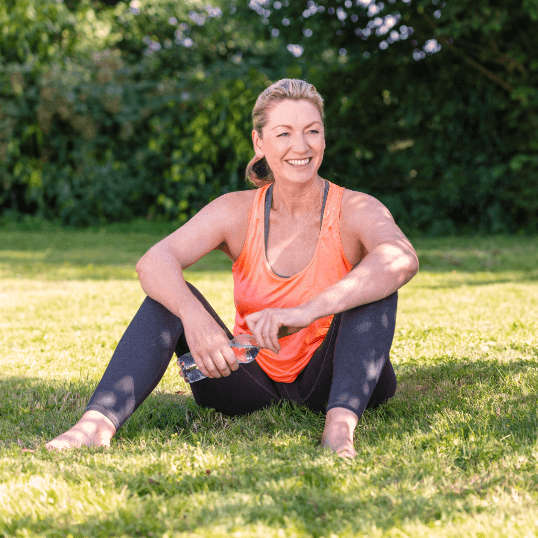Woman sitting in grass and smiling